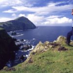Walker admiring the seacliffs of north Clare Island, Co Mayo, Ireland.